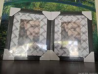 Front view of both black frames in packaging