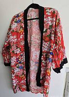Full kimono robe on hanger showing floral pattern and black trim
