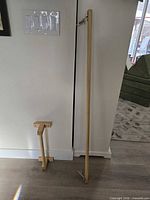 Two wooden handrails leaning against wall showing overall size and hardware