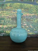 Full view of turquoise ceramic decanter with stopper inserted