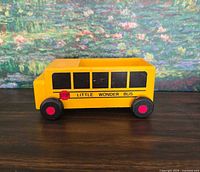 Left-side view of Little Wonder wooden toy bus showing graphics and paint condition