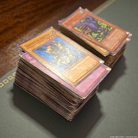 Two stacks of assorted Yu-Gi-Oh cards on table