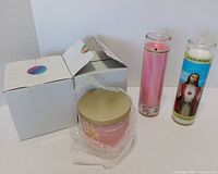 Overall lot showing two boxed Aeropostale jar candles, one unboxed jar candle, pink pillar candle, and Sacred Heart pillar candle