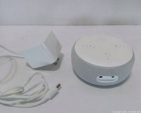 Echo Dot speaker and power adapter side by side