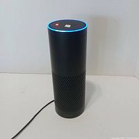 Amazon Echo Plus standing, LED ring lit, power cable attached