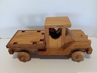 Side view of full wooden truck showing cab, flatbed and wheels