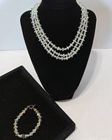 Necklace displayed on bust with bracelet nearby