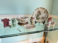 Group shot showing all porcelain items on glass shelf