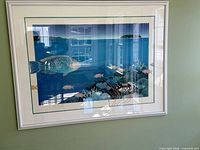 Full view of framed print on wall showing marine scene, white frame, matting