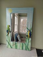 Front view showing full painted frame, mirror and carved parrots