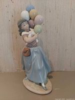 Full view of figurine showing girl, balloons, colors and glaze