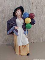 Front view of Balloon Lady figurine showing dress, shawl and balloons