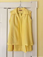 Blouse and scarf displayed on hanger with skirt beneath