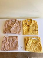 Four pajama pieces laid out: peach set folded left, yellow set folded right