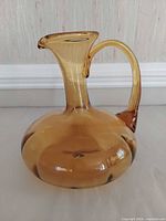 Front view of amber glass pitcher showing body, spout and handle