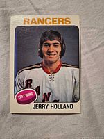 Front of 1974-75 O-Pee-Chee Jerry Holland Rangers card