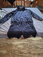 Full view of navy hoodie and shorts laid flat on bed