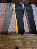 Front view of three joggers showing colors and side stripes