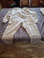 Full view of matching sweatshirt and sweatpants laid flat