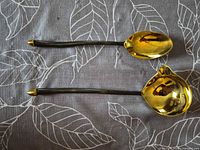 Top view of brass serving spoon and ladle showing bowls and handles