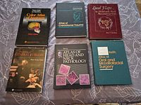 All six medical textbooks laid out on surface