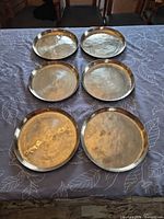 Six brass trays front view on table