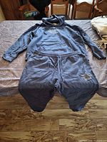 Full view of blue fleece hoodie and sweatpants laid out