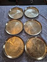 Six brass trays front view showing finish and patina