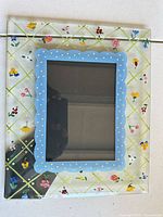 Front view showing floral glass design and blue scalloped mat