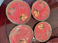 All four red Octavia Hill Collection plates arranged on table