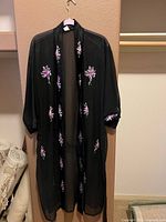 Full view of black embroidered cover up hanging