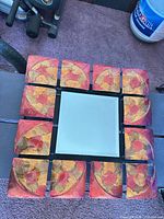 Front view of square mirror with surrounding ceramic tiles