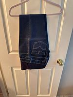 Jeans folded over hanger showing overall color and fabric
