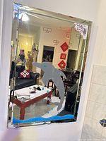 Front view of rectangular dolphin mirror with mirrored frame and painted design