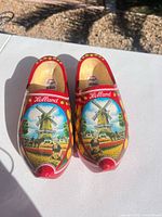 Top view of red wooden clogs showing windmill/tulip graphic and Holland text