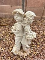 Front angle of resin boy and girl statue on gravel