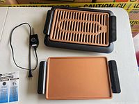 Overall lot showing grill base, grill plate, griddle plate, thermostat cord, manual