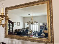 Front view of large rectangular gold framed mirror mounted on wall