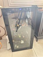Full view of mini wine fridge showing glass door, touch controls and interior racks