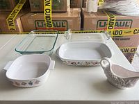 Full set showing two glass bakers, two ceramic fruit-motif bakers, and gravy boat