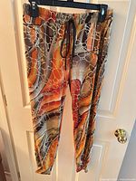 Front view of patterned drawstring pants hanging on hanger