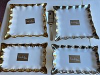 Four square trays with gold and silver rims and serving spoon