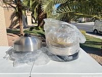Whole oven and accessories wrapped in plastic showing dome lid and rack