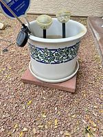 Side view of ceramic planter showing ivy and lattice design, saucer underneath