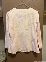 Back view of salmon jacquard long-sleeve blouse