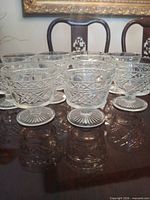 Group of ten clear cut glass footed sherbet glasses on table