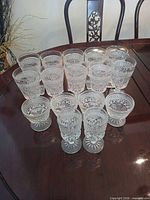 Sixteen clear cut crystal sherbet goblets arranged on dining table