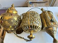 Three brass Moroccan style hanging lanterns with cords and chains