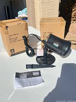 Projector, stake, manual and boxes on table