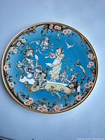 Front view of blue porcelain plate with Snow White and dwarfs scene and gold rim